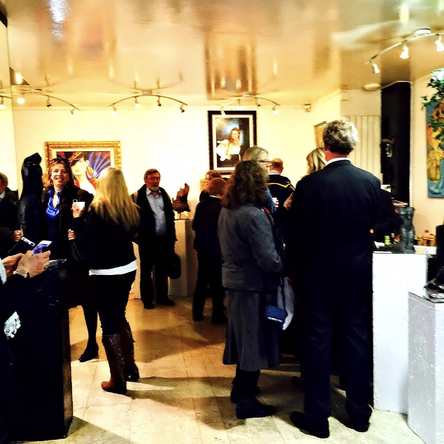 The Galerie Thuillier room crowded with visitors among the paintings on the opening night