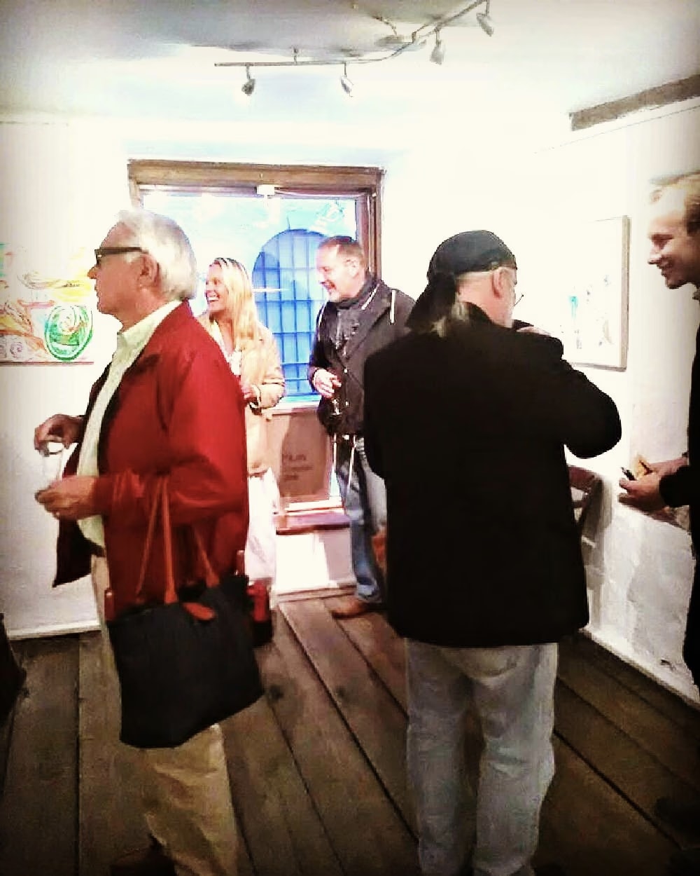 Besucher im Gespräch zwischen den Werken auf dem Holzboden der Galleri T in Stockholm