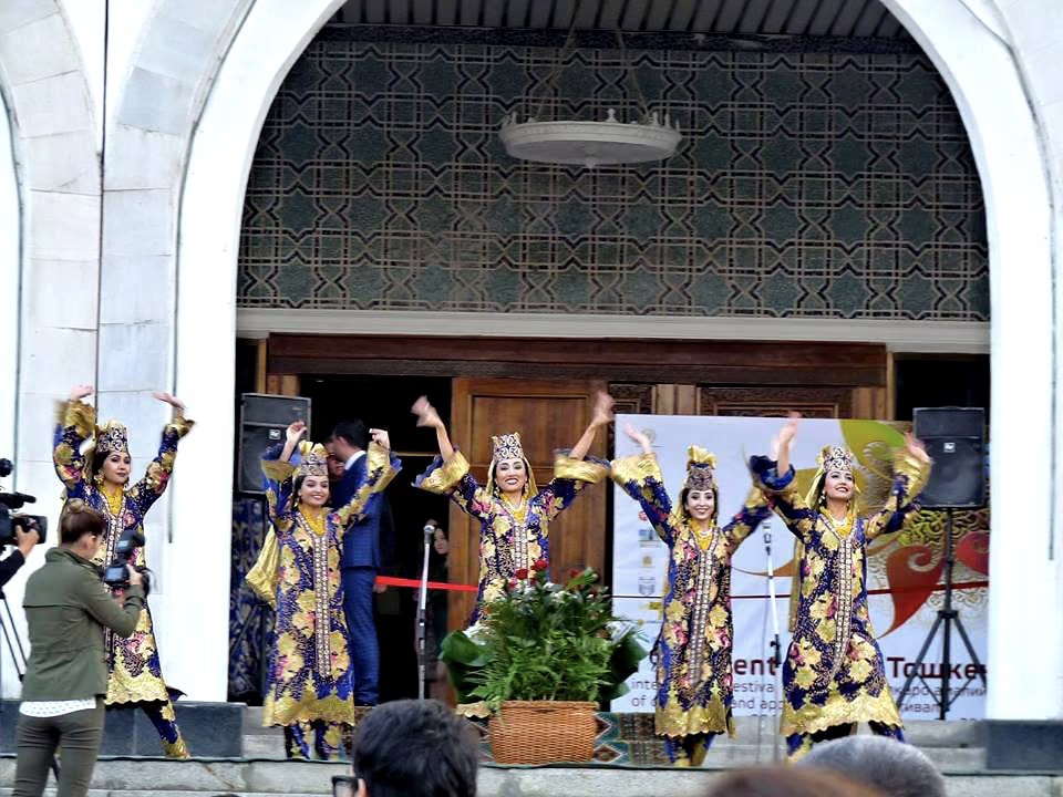 Dancers in blue and gold embroidered dresses at the opening of the Tashkent festival