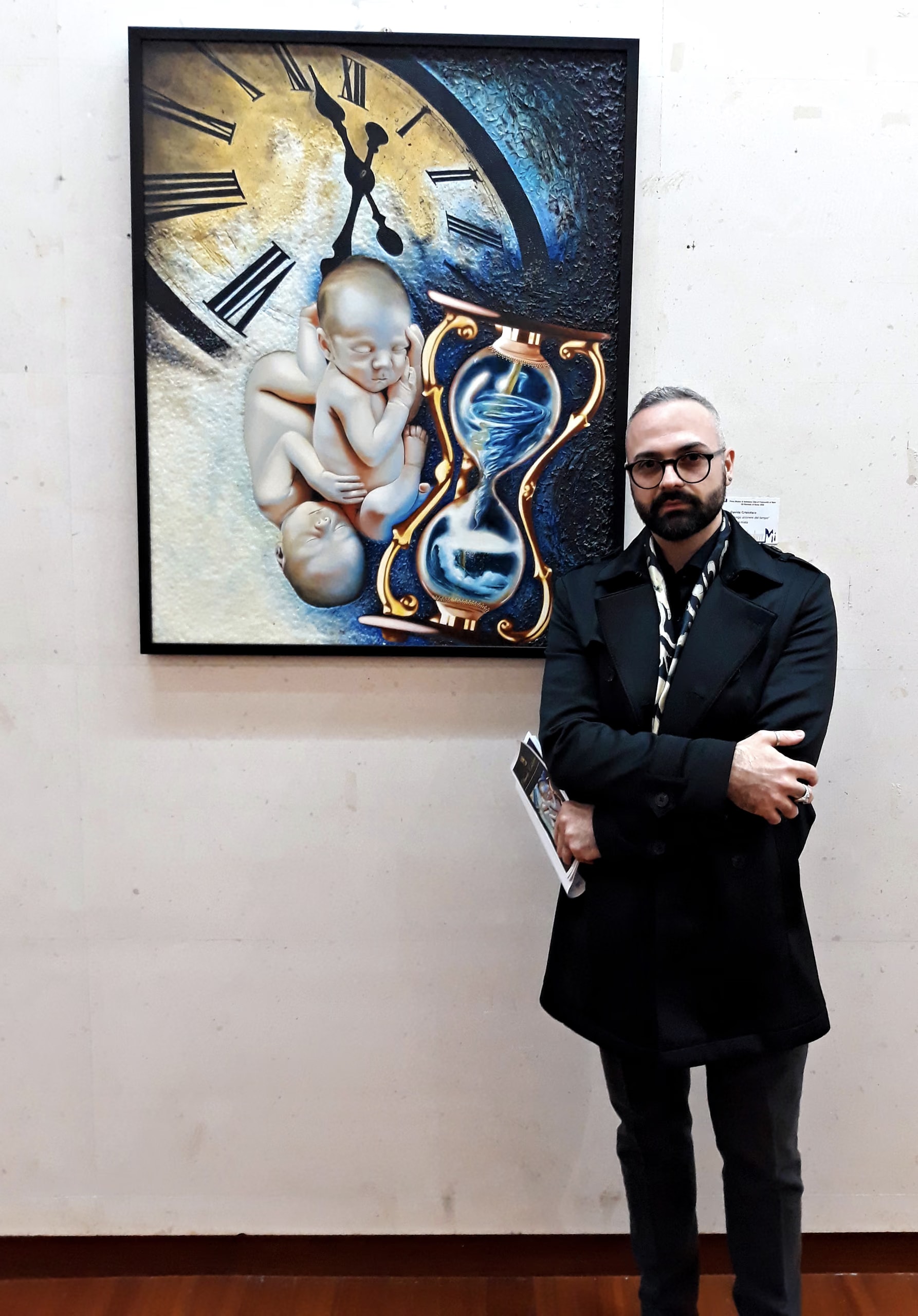 Davide Cristofaro debout à côté du Long Écoulement du Temps, accroché au mur du Museo Michetti