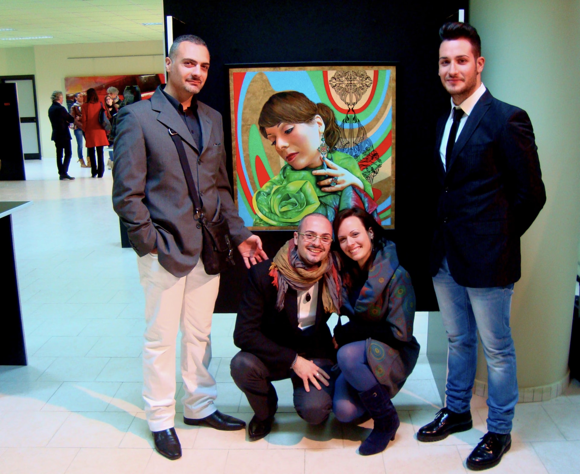Giuseppe Cristofaro, Davide y Morena agachados y Antonio ante el retrato Morena en la inauguración de Young Showcase 2013