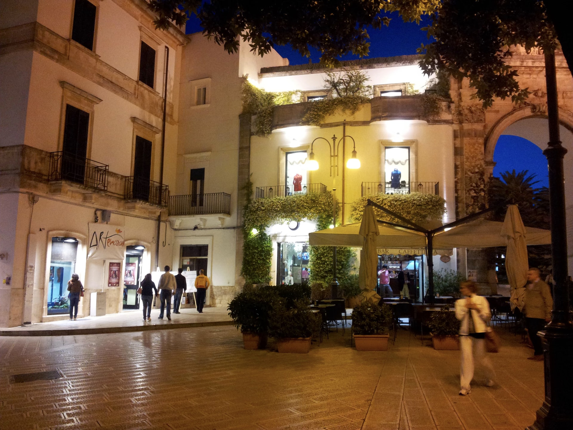 I locali di «Echi di perle artistiche» in piazza XX Settembre a Martina Franca, con lo striscione di Artemozioni, accanto all’Arco di Santo Stefano, la sera
