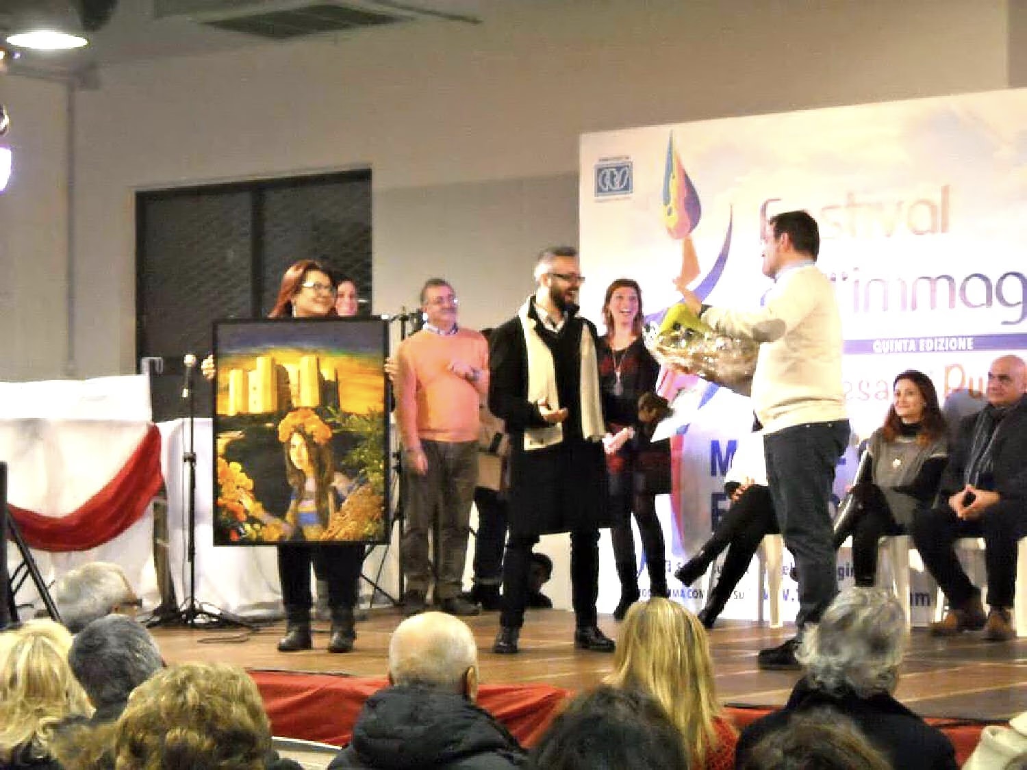 Auf der Bühne des Festival dell’Immagine 2015 überreicht Tonio Cantore Davide Cristofaro den Publikumspreis, daneben wird Castel del Monte und die Hofdame gehalten