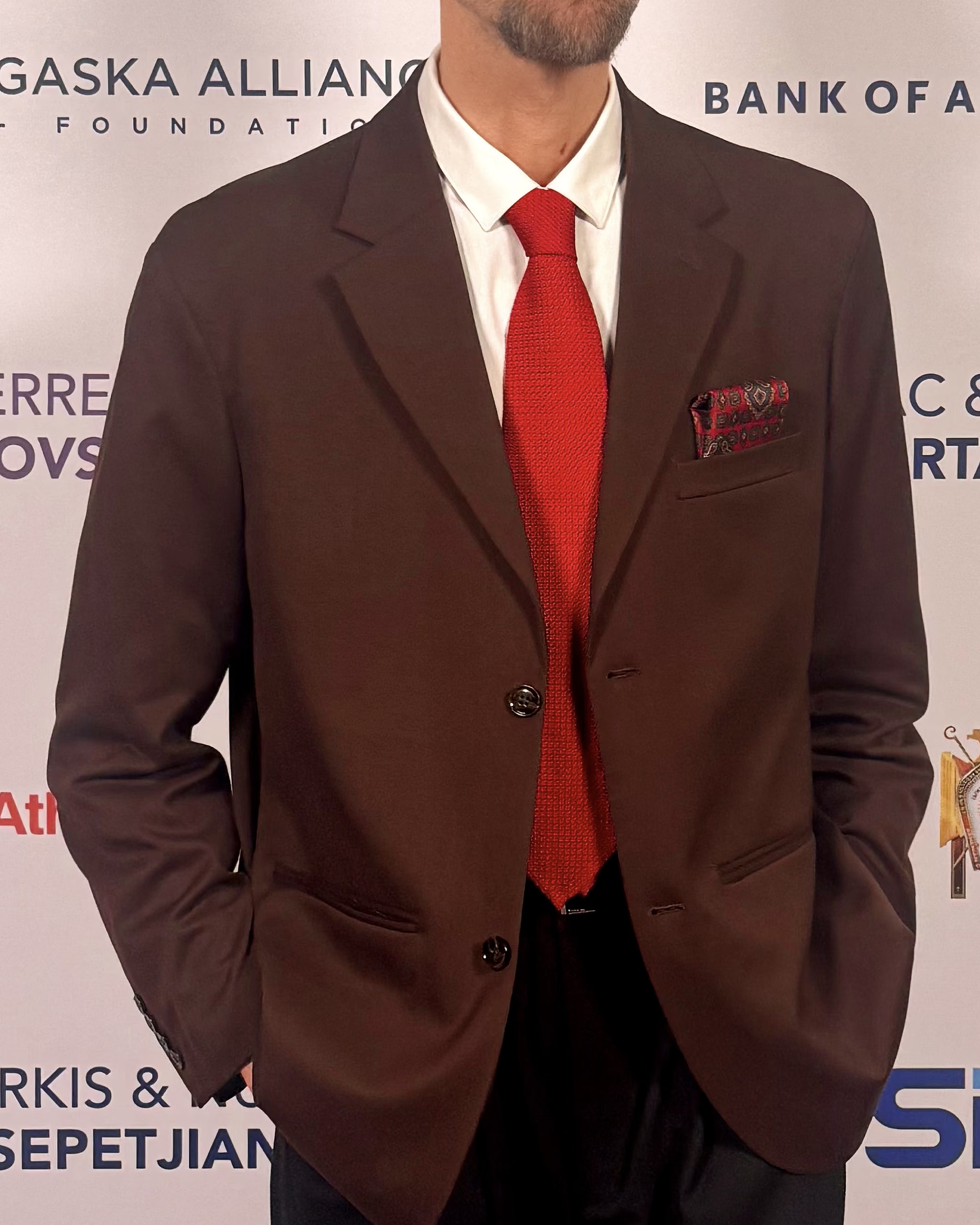 Detail of the red Davide Cristofaro large-gauze grenadine silk tie on Raimondo Rossi’s brown jacket