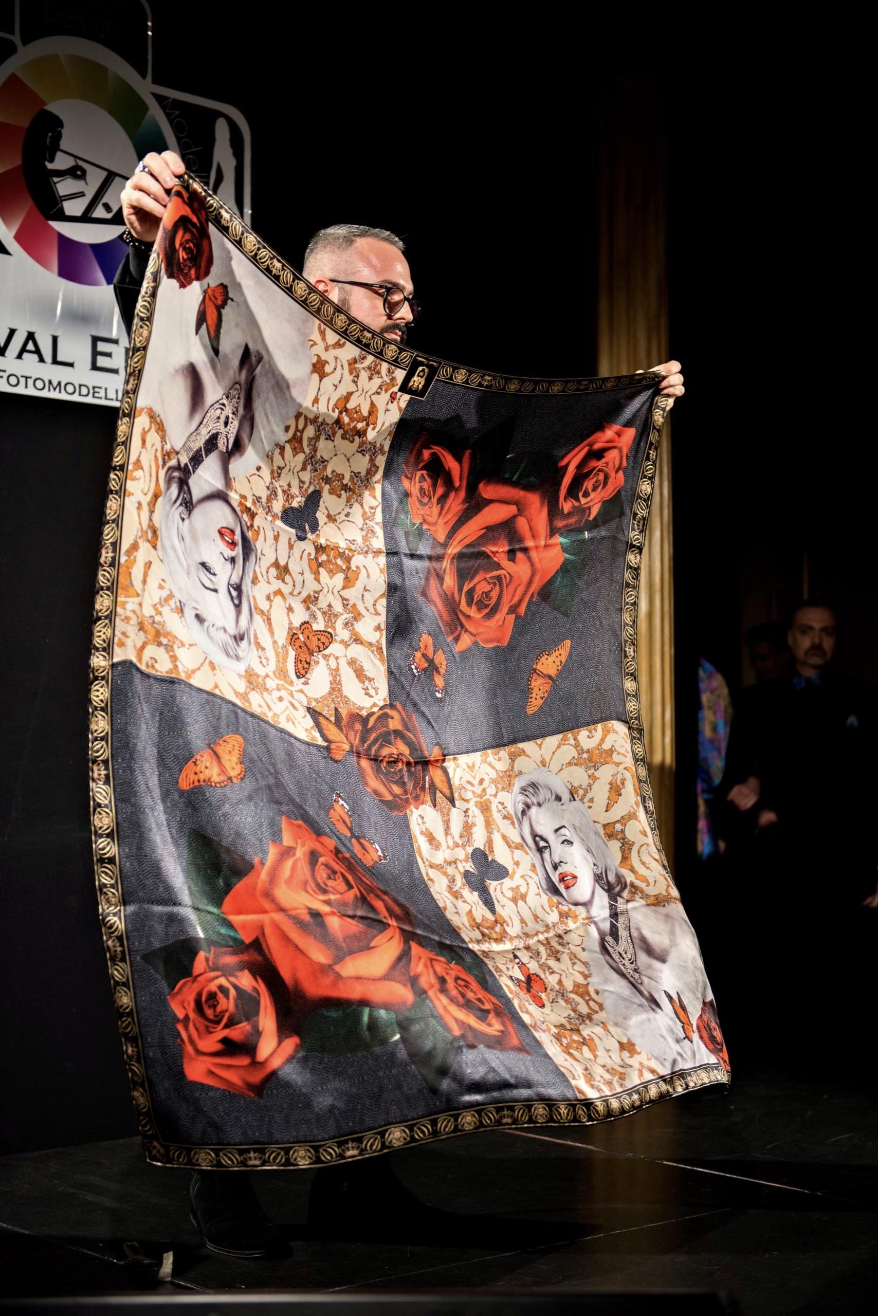 Davide Cristofaro zeigt dem Publikum auf der Bühne ein Seidentuch mit roten Rosen