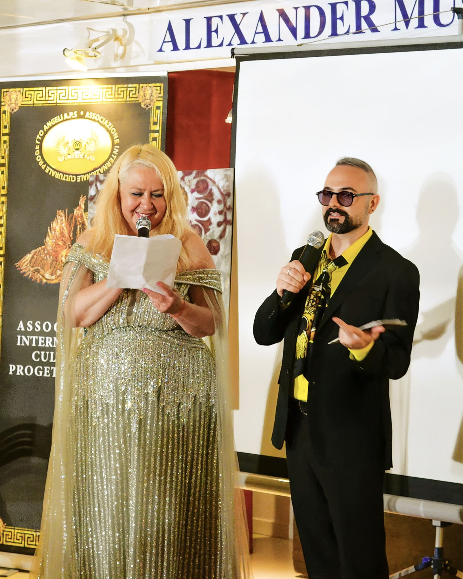 Davide Cristofaro spricht am Mikrofon neben Aida Abdullaeva im Alexander Museum Palace Hotel