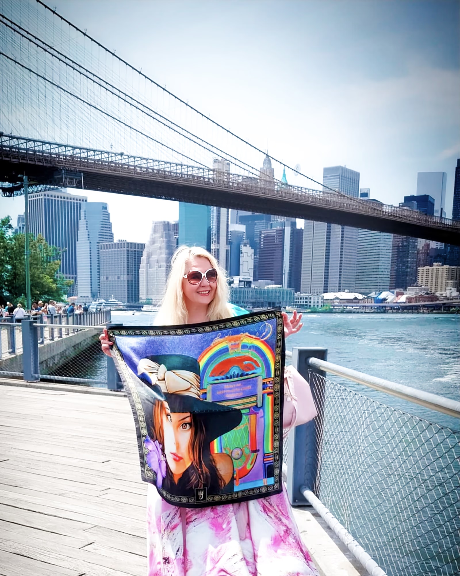 Il foulard Fanny aperto sul lungofiume sotto il ponte di Brooklyn, con i grattacieli di Manhattan sullo sfondo