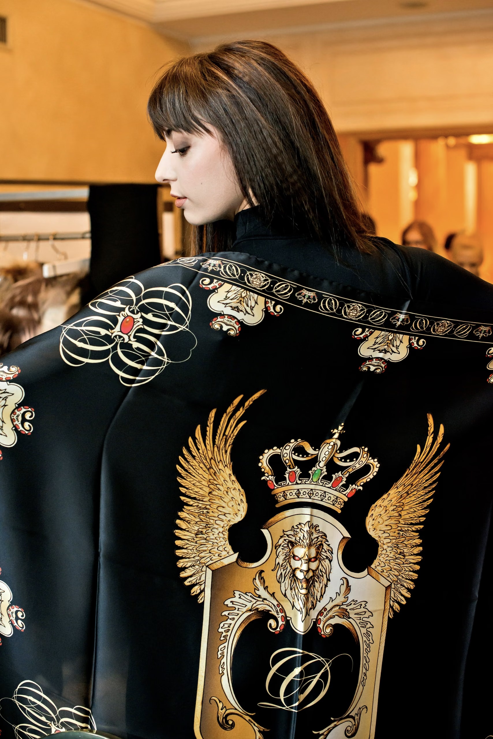 Model von hinten in einem schwarzen Seidentuch mit dem Wappen von Davide Cristofaro