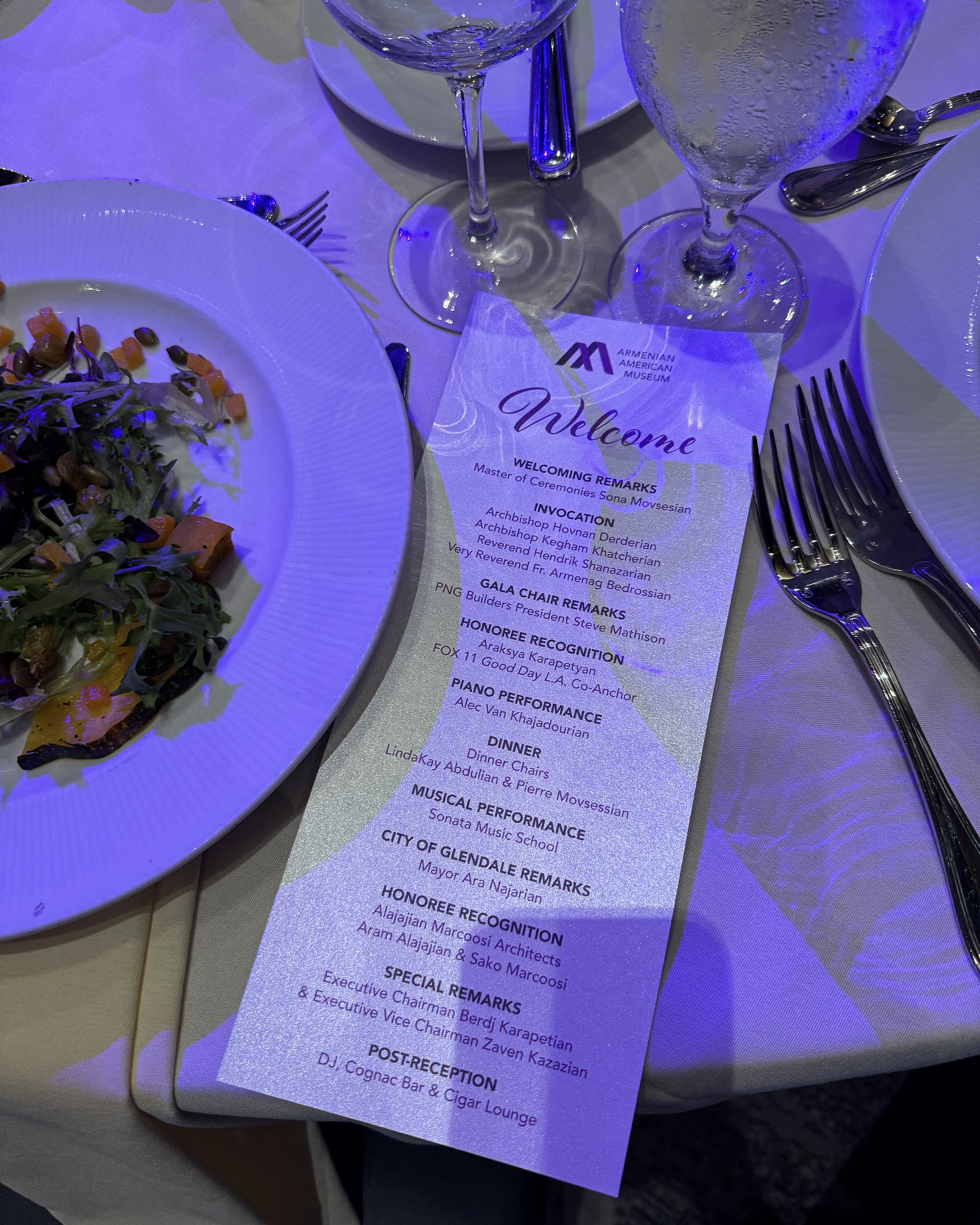 The dinner menu of the Heritage Gala 2025 on the plate, under the blue lights of the ballroom