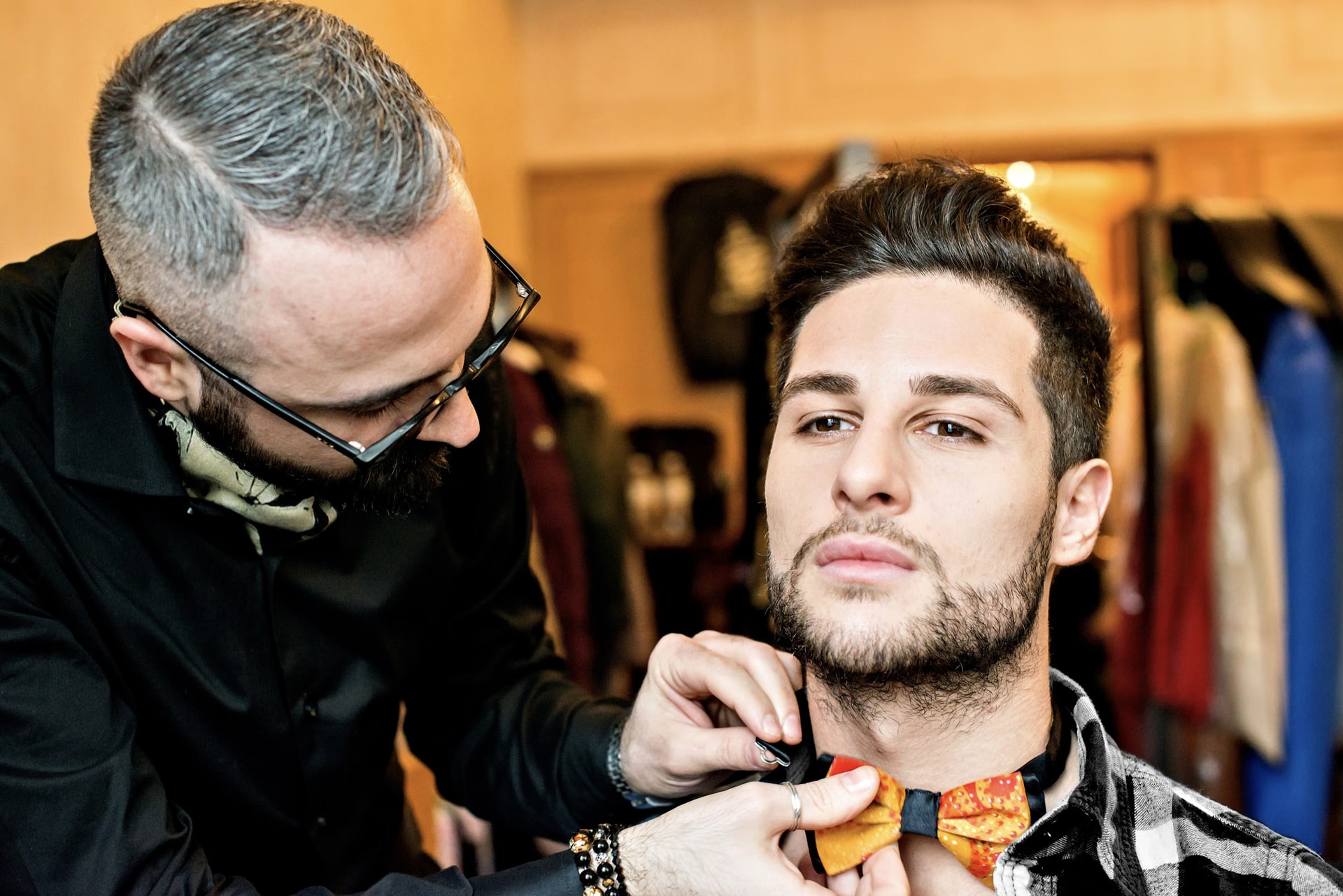 Ein Model hinter den Kulissen, während ihm die Fliege gebunden wird