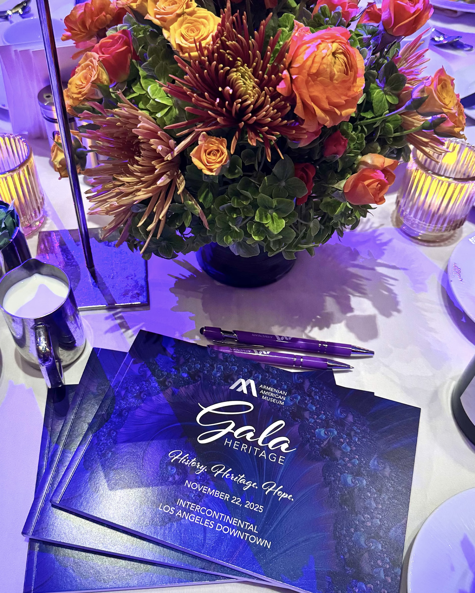The Heritage Gala 2025 table with the flower arrangement and the evening programme